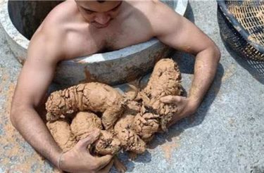 Homem entra em esgoto para resgatar 5 cachorrinhos que se afogavam na lama